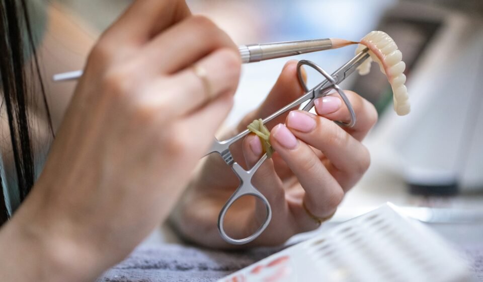 Dental technician working on a prosthetic denture in a dental laboratory