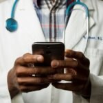 Doctor using a smartphone to support digital healthcare and health technology