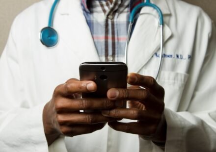 Doctor using a smartphone to support digital healthcare and health technology