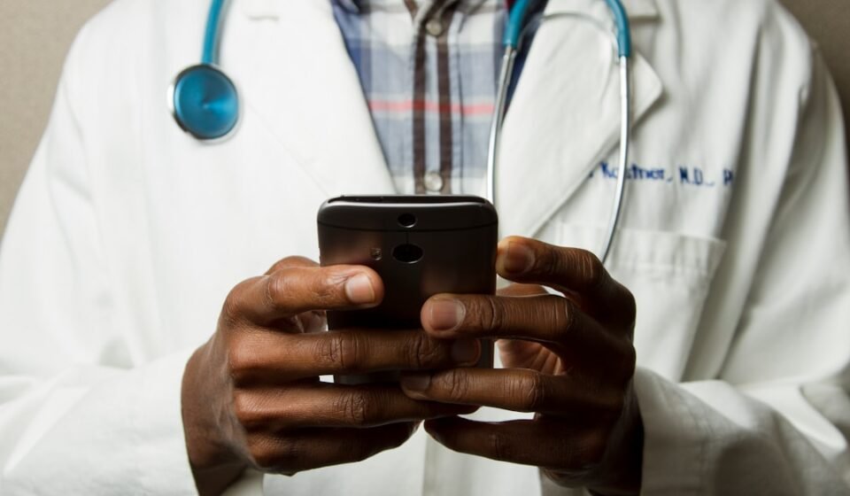 Doctor using a smartphone to support digital healthcare and health technology