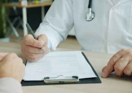 Healthcare professional reviewing medical records with a patient while discussing healthcare coverage