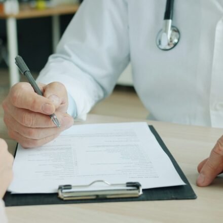 Healthcare professional reviewing medical records with a patient while discussing healthcare coverage