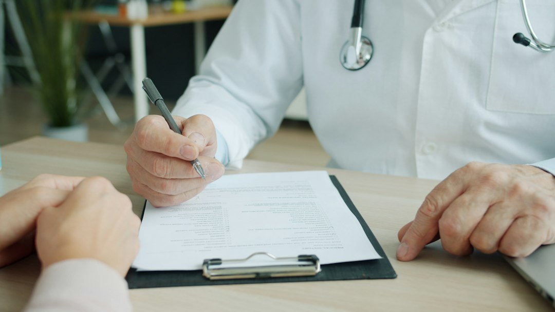 Healthcare professional reviewing medical records with a patient while discussing healthcare coverage
